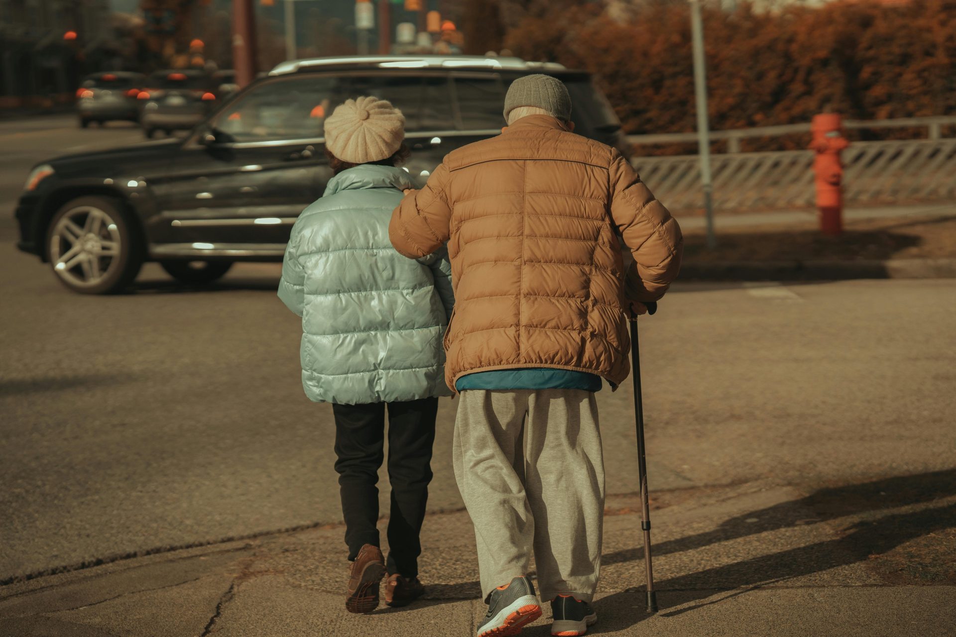 A senior couple walks down a Vancouver street, supporting each other.