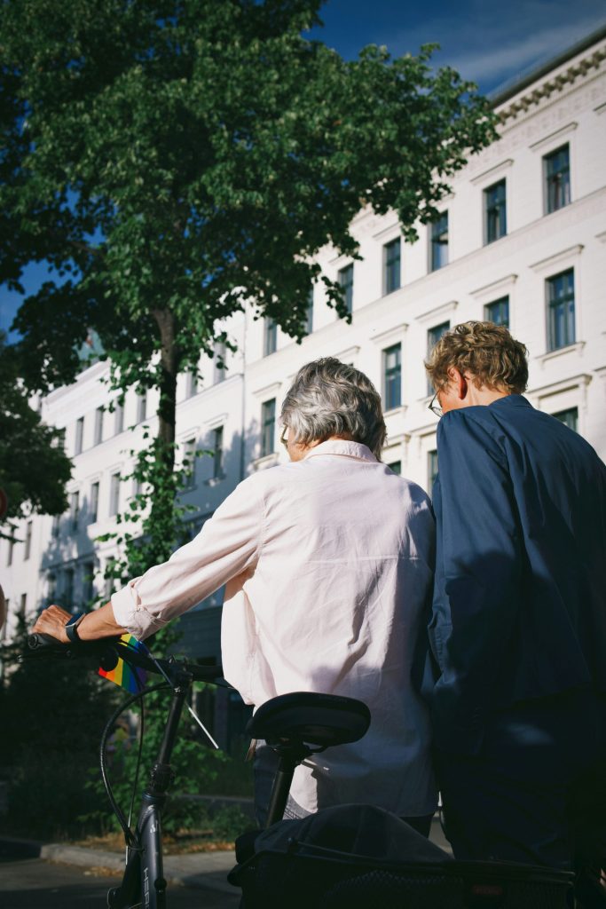 a man and a woman riding a bike down a street